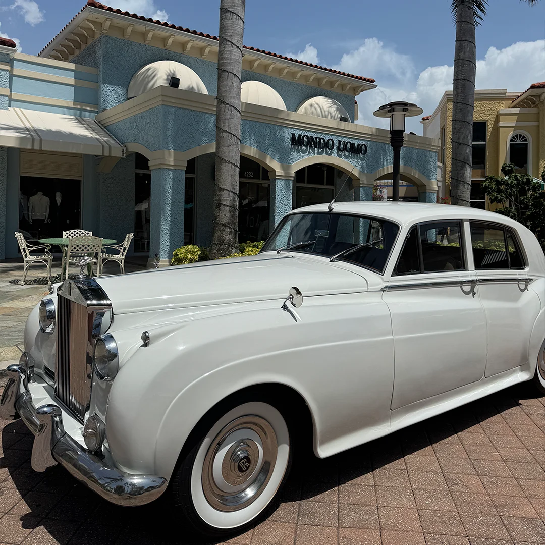Vintage white Rolls Royce Silver Cloud II parked outside Mondo Uomo menswear boutique in Naples, Florida