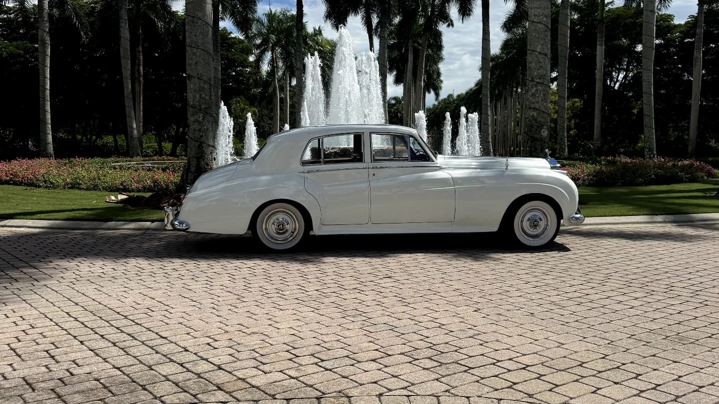 Cream white 1960 Rolls Royce Silver Cloud II parked on the fountain arrival drive at Tiburon Golf Club in Naples Florida