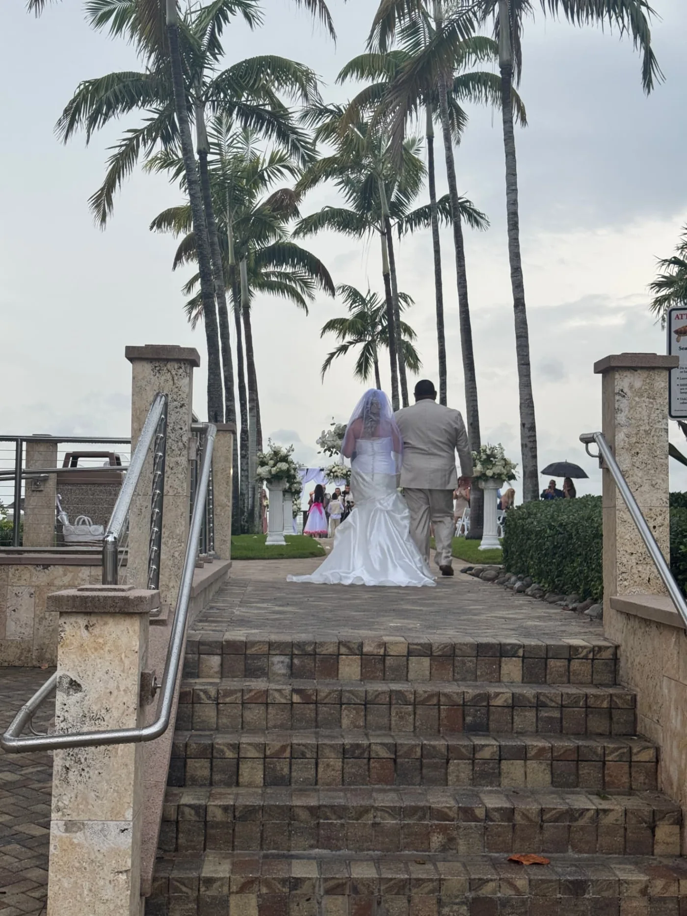 Robbins Wedding bride approaching the palm-lined beach ceremony with a guest for a wedding in Naples, Florida