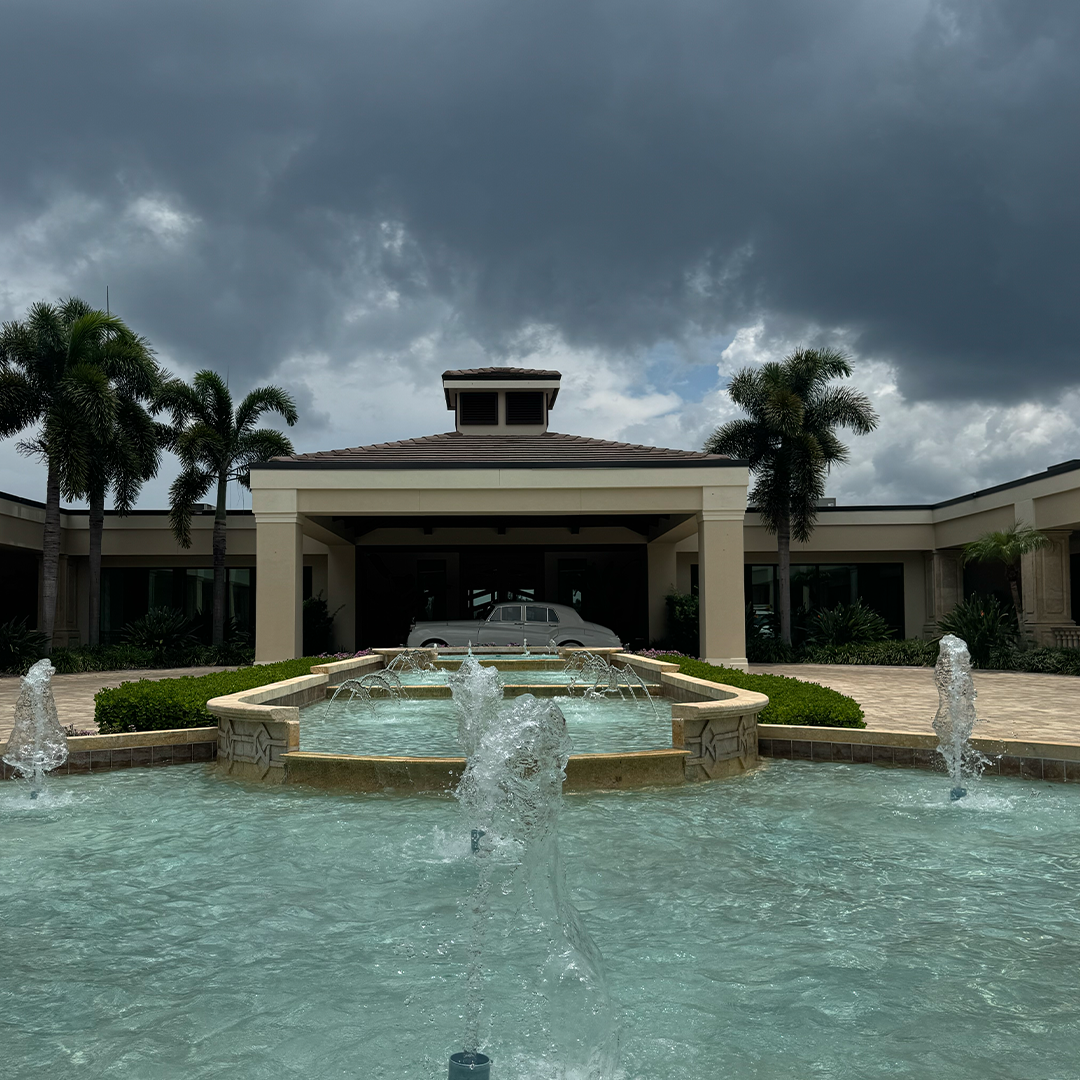 Vintage Rolls Royce Silver Cloud II framed by fountains and palms at the Vineyards Country Club entrance in Naples, Florida
