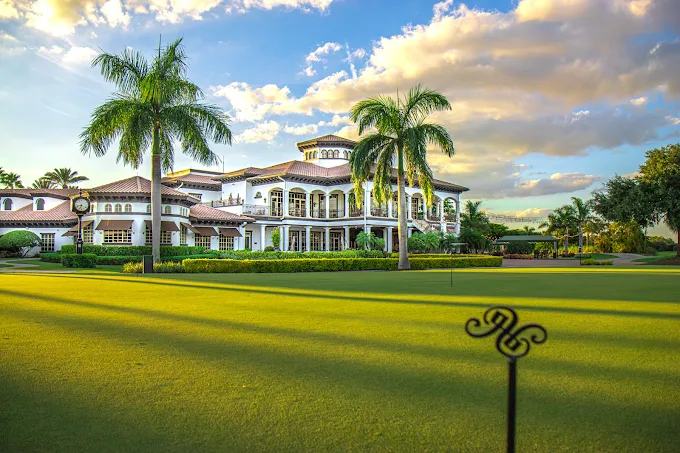 The Club at Renaissance wedding venue — Mediterranean-inspired clubhouse with palm trees and manicured golf course at golden hour in Fort Myers, Florida