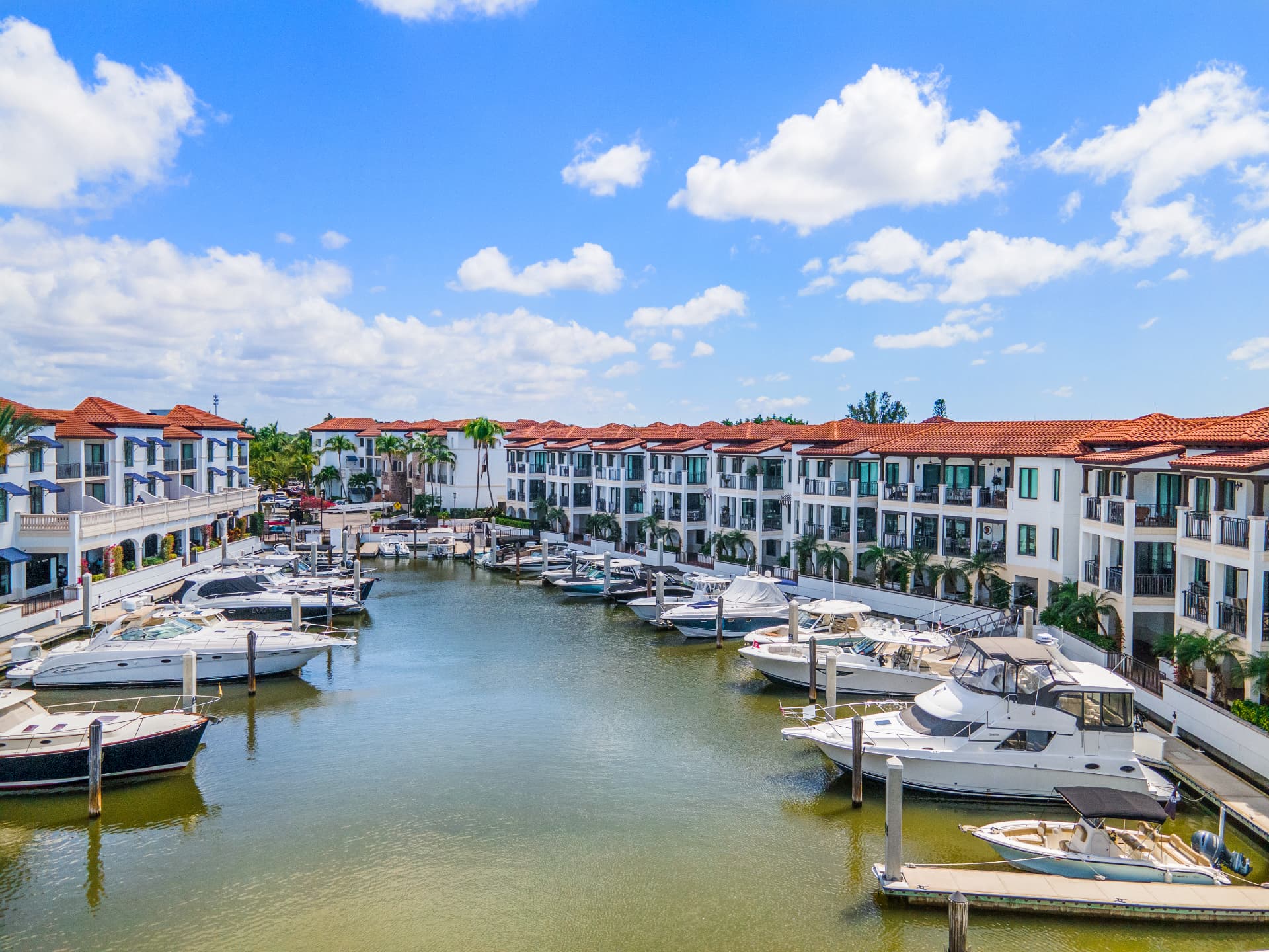 Naples Bay Resort and Marina wedding venue — aerial view of the private marina lined with luxury yachts and Mediterranean-style villas in Naples, Florida
