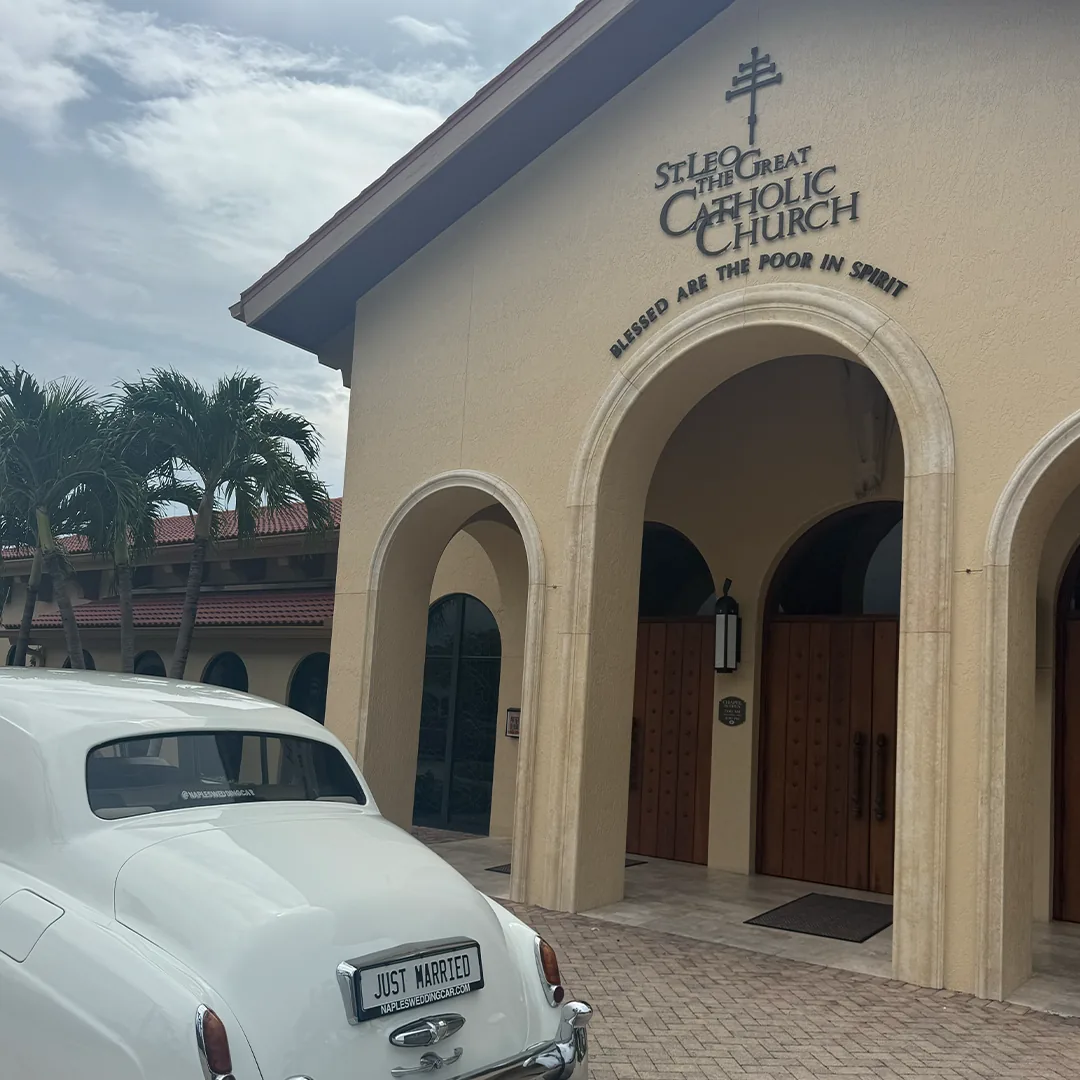 Rear view of a vintage white Rolls Royce Silver Cloud II with Just Married plate parked at St. Leo the Great Catholic Church in Bonita Springs, Florida