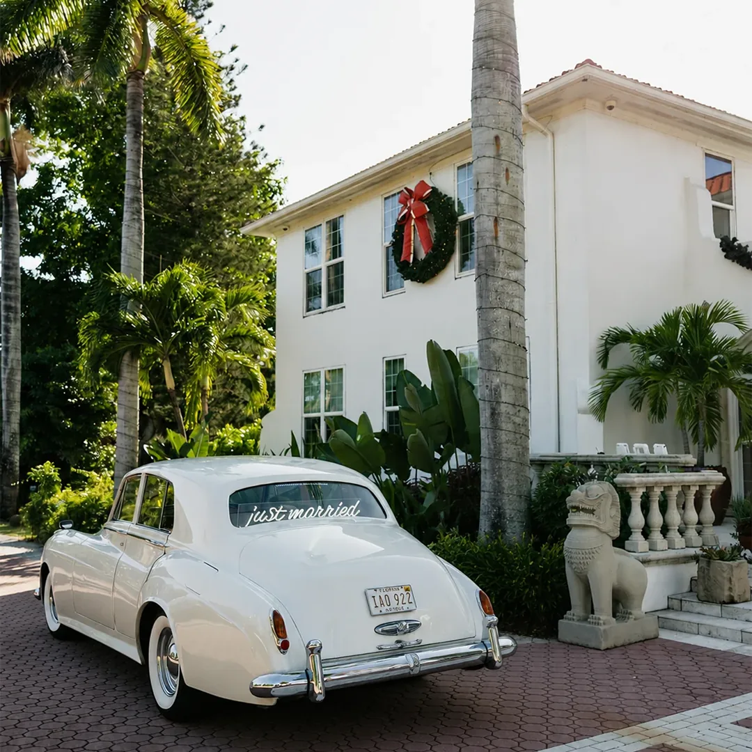 Vintage cream white Rolls Royce Silver Cloud II with Just Married sign parked at Shangri-La Springs in Bonita Springs, Florida