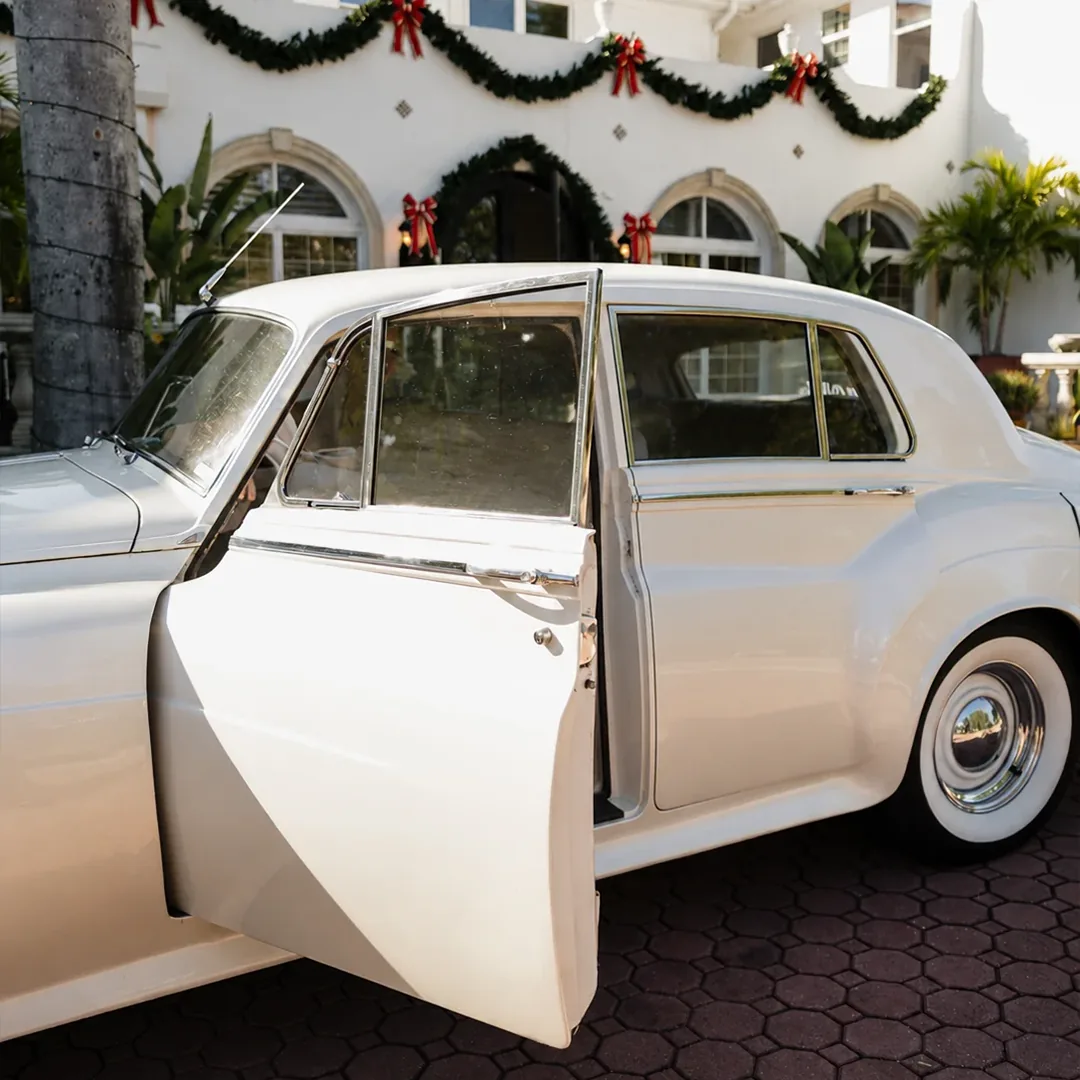 Rear door open on a vintage cream white Rolls Royce Silver Cloud II beneath holiday garland at Shangri-La Springs in Bonita Springs, Florida