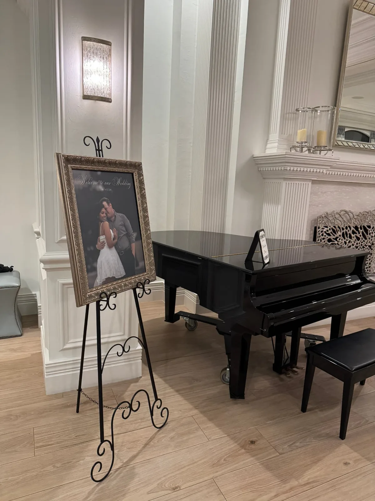 Framed welcome to our wedding sign on a gold easel beside a grand piano inside The Club at Grandezza in Estero Florida