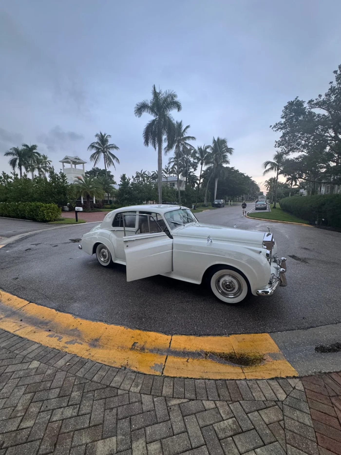 Robbins Wedding cream-white 1960 Rolls-Royce Silver Cloud II waiting beneath palms near 8th Street Beach for a wedding in Naples, Florida