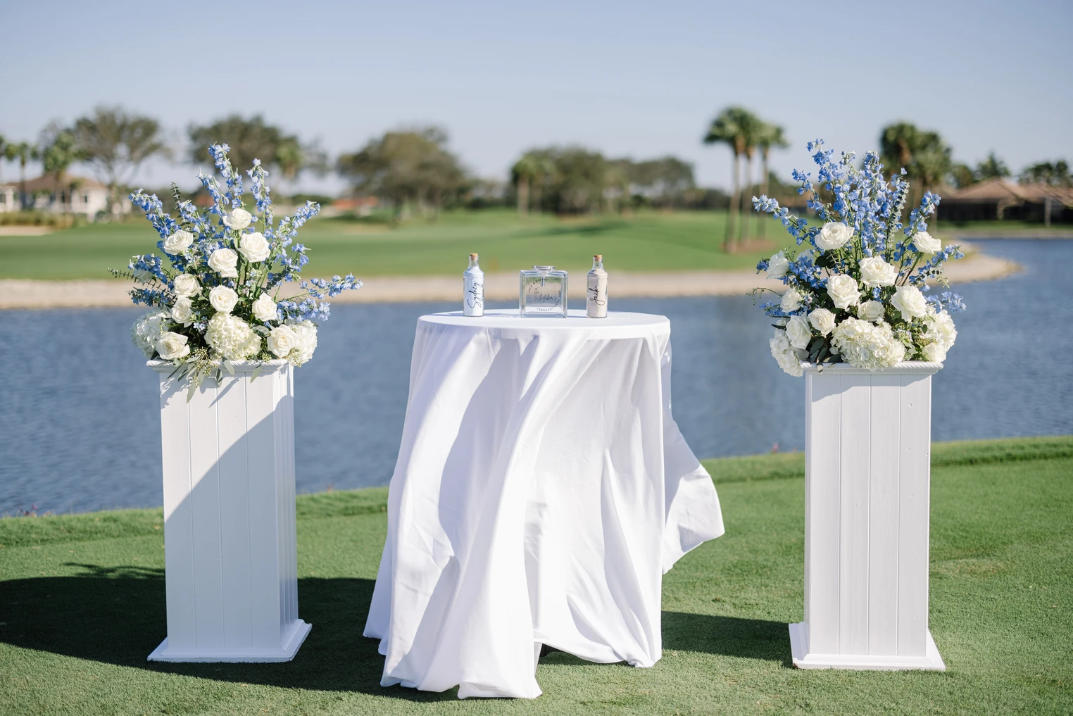 Kensington Golf & Country Club wedding venue — elegant lakeside cocktail setup with white roses and blue florals overlooking the golf course in Naples, Florida