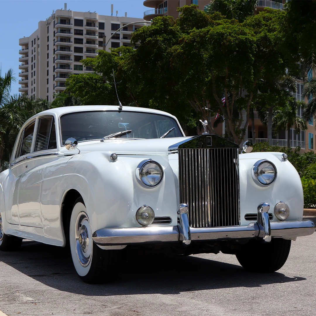 Vintage white Rolls Royce Silver Cloud II front quarter view parked in downtown Naples, Florida for wedding transportation
