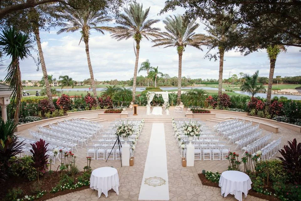 The Strand wedding venue — palm-framed outdoor ceremony terrace overlooking the championship golf course and lakes in Naples, Florida