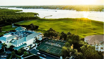 Windstar on Naples Bay wedding venue — aerial sunset view of the waterfront club, golf course, and tennis courts along Naples Bay in Florida