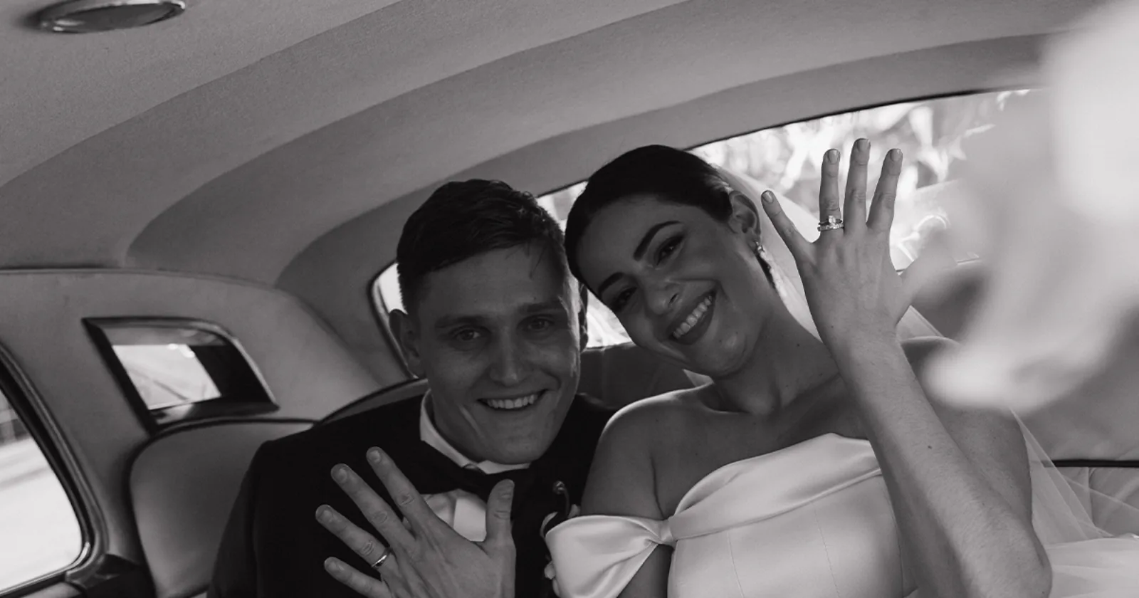 Gabby and Stephen Wedding Rings Rolls-Royce Back Seat Naples FL Newlyweds Gabby and Stephen holding up their wedding rings in the champagne leather back seat of a vintage Rolls-Royce Silver Cloud II after their ceremony at Saint William Catholic Church in Naples Florida