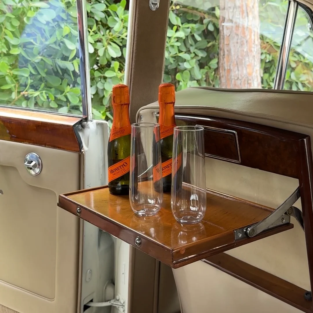 Champagne service inside the vintage 1960 Rolls Royce Silver Cloud II for wedding transportation in Naples, Florida