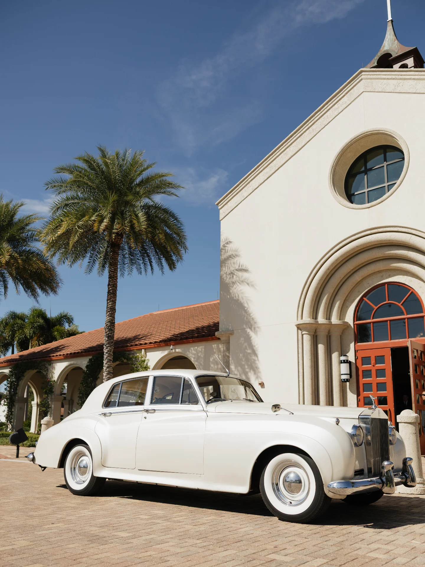 Saint William Catholic Church wedding — vintage cream-white 1960 Rolls-Royce Silver Cloud II parked outside the Naples venue