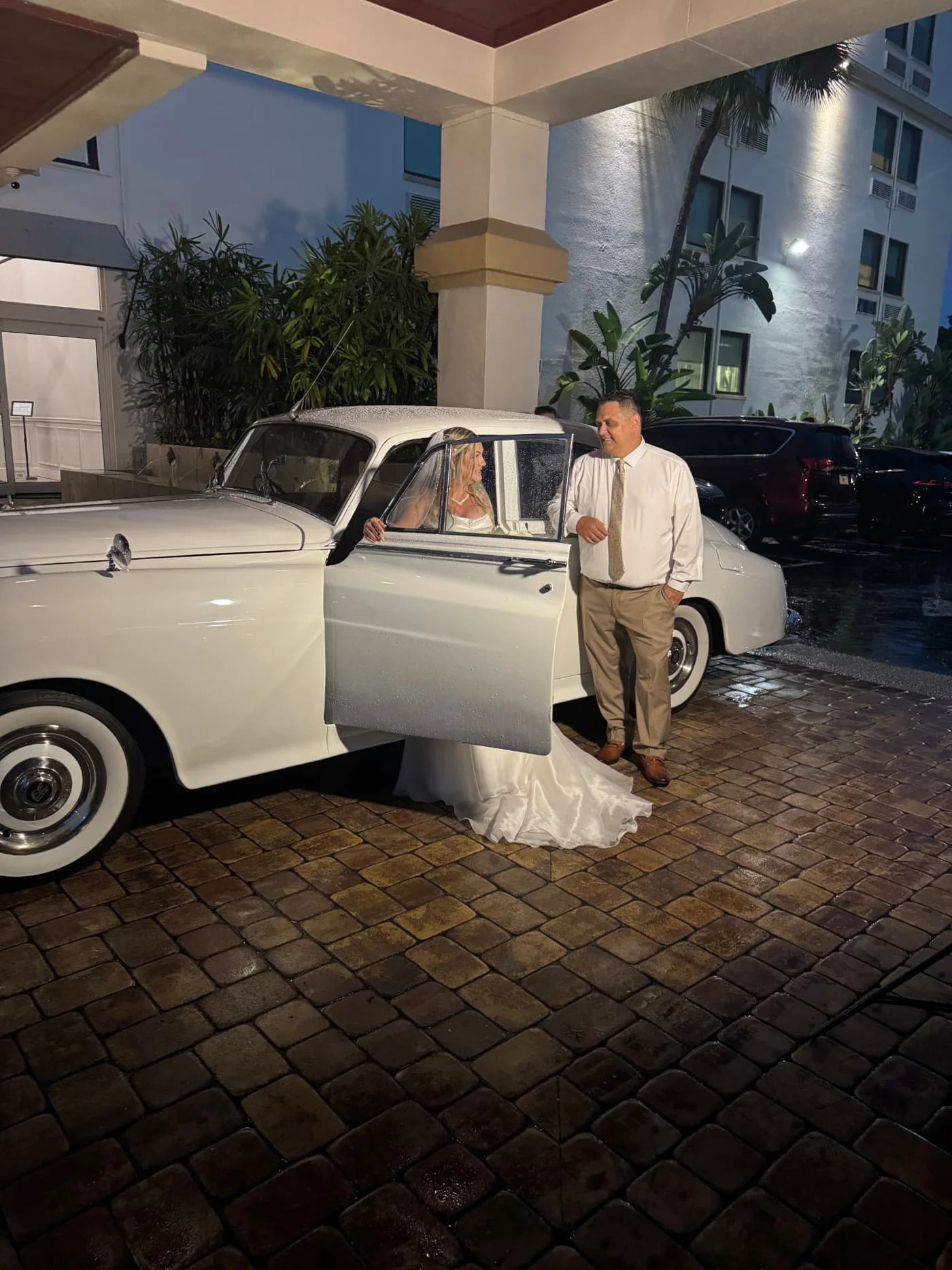 Robbins Wedding bride and groom beside the open door of a cream-white Rolls-Royce at Bayfront Inn Naples for their wedding in Naples, Florida