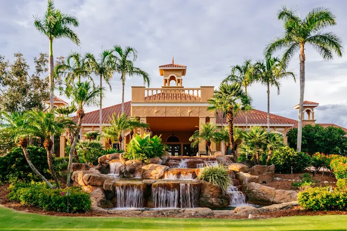 Vasari Country Club wedding venue — Mediterranean-inspired clubhouse with a cascading waterfall and towering palm trees in Bonita Springs, Florida