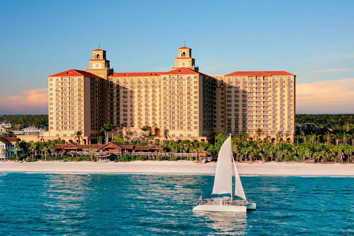 The Ritz-Carlton, Naples Wedding Venue — Naples, FL The Ritz Carlton Naples oceanfront resort exterior with palm lined pool terraces overlooking the Gulf of Mexico beach in Naples Florida