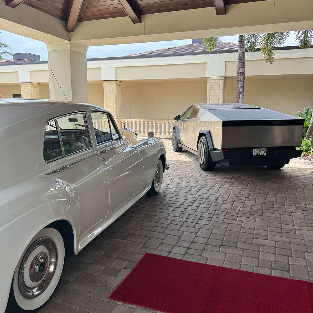 Vintage white Rolls Royce Silver Cloud II parked beside a modern vehicle on the red carpet at Vineyards Country Club in Naples, Florida