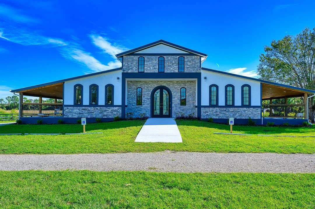 The White Rose wedding venue — Tuscan-inspired stone and stucco event hall with wraparound porch and manicured lawn in Naples, Florida