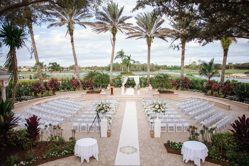 The Strand wedding venue — palm-framed outdoor ceremony terrace overlooking the championship golf course and lakes in Naples, Florida